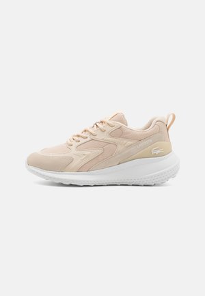 Beige athletic shoe with suede and mesh materials, a white sole, and tonal accents. Features laces and a logo on the side.