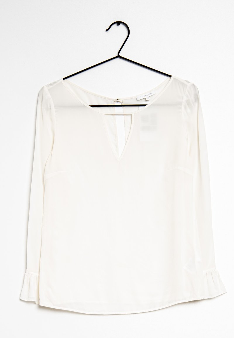 Blusa bianca a maniche lunghe con scollatura a V. Realizzata in un tessuto morbido, presenta sottili dettagli a ruches ai polsini e una chiusura sul retro.