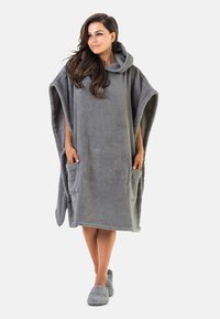 Poncho grigio con cappuccio realizzato in morbido tessuto plush, con due tasche anteriori e una forma ampia e oversize per garantire comfort.