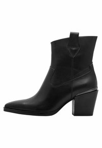 Bottine en cuir noir avec un bout pointu, des panneaux latéraux élastiques et un large talon bloc. Dispose d'une languette à l'arrière pour un enfilage facile.