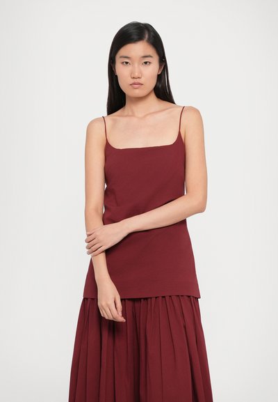 Burgundy, sleeveless top with a square neckline, made of soft fabric, featuring a straight cut and layered design. No visible patterns or hardware.