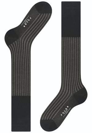 Calcetines gris rayados con diseño acanalado. Presentan una puntera y un puño oscuros, fabricados con un material suave y texturizado. Marca visible en la suela.