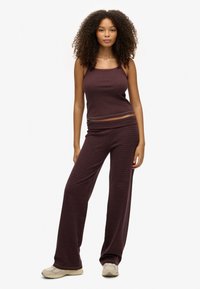 Stribet, maroon strik loungewear sæt med en tætsiddende tanktop med spaghetti-stropper og løstsiddende bukser med bred ben og elastisk talje.