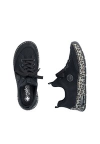 Paire de chaussures décontractées noires à lacets avec des accents imprimés léopard sur les semelles, l'une vue de dessus, l'autre de côté.