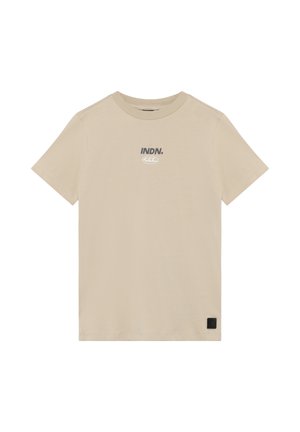Beige katoenen t-shirt met korte mouwen, ronde hals en bedrukt tekst "INDN." in grijs; heeft een klein zwart merketiket aan de zoom.