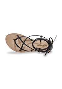 Sandal en cuir noir avec des brides entrecroisées sur une semelle en cuir beige, présentant des coutures contrastantes et un accent noué autour de la cheville.