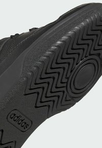 Sole di sneaker nera con motivo a zigzag. Caratterizzata da un distintivo logo e gomma testurizzata per aderenza e durata.