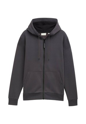 Sudadera gris con cremallera, capucha, bolsillos frontales y cordones. Fabricada con tejido texturizado, presenta un corte ligeramente holgado y puños.