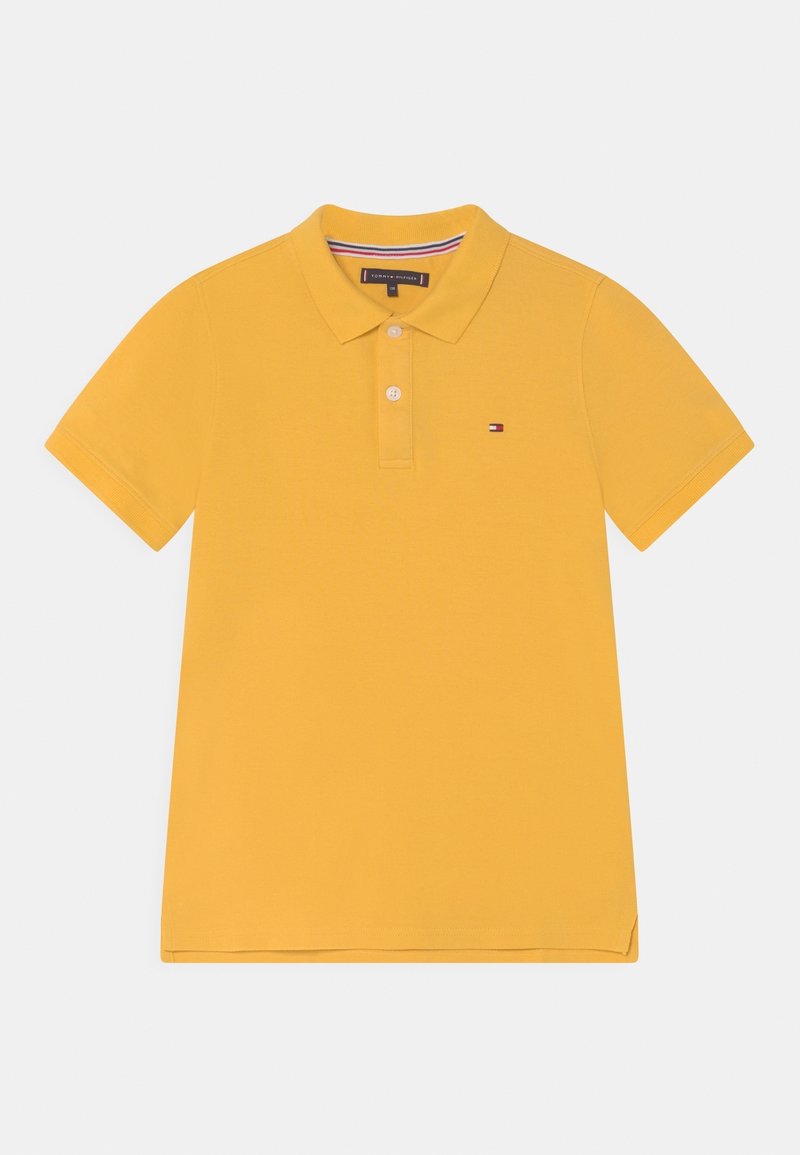 Polo jaune à manches courtes avec col, patte à deux boutons et petit logo Tommy Hilfiger sur la poitrine.