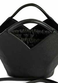 Juodas tekstūruotas odinis rankinukas su dviem apvaliais rankenėlėmis ir audiniu su raišteliu viduje.