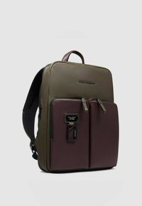 Zaino verde oliva e bordeaux con finitura in pelle liscia, due tasche anteriori con zip e spallacci imbottiti regolabili. Dotato di manico superiore.