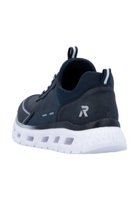 Baskets de sport marines avec un matériau texturé, semelle en caoutchouc blanc avec des trous de ventilation et accents gris, y compris un logo sur le talon.