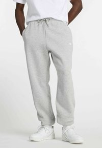 Grijze joggingbroek van zachte stof, voorzien van een elastische tailleband met trekkoord, zijzakken en een taps toelopend been.