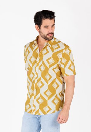 Chemise à manches courtes avec boutons en jaune et crème, ornée d'un motif géométrique. Présente un col et un tissu léger.