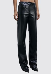 Pantaloni in pelle nera con design a vita alta, davanti piatto, tasche laterali e taglio dritto, caratterizzati da una texture liscia e lucida.