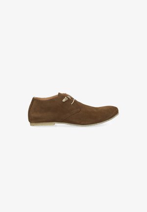 Chaussure à lacets pour homme en daim marron avec une silhouette élancée et une semelle de couleur claire sur fond blanc.
