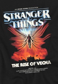 Schwarzes T-Shirt mit einem grafischen Design, das eine zentrale Figur in lebhaften Farben von Rot, Blau und Orange zeigt, umgeben von einem stilisierten "Stranger Things"-Logo.