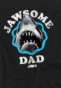 Black t-shirt featuring a graphic of a shark's open mouth with sharp teeth, surrounded by blue accents and white text reading "JAWSOME DAD."