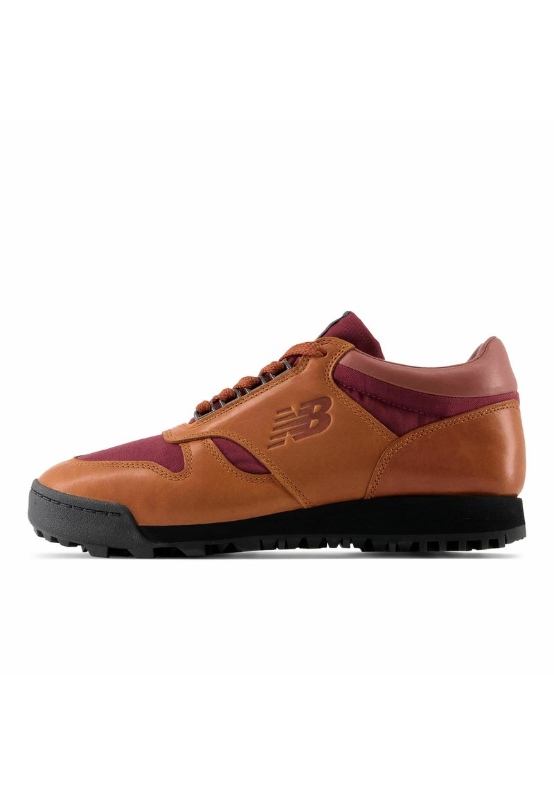 Basket en marron et bordeaux avec semelle noire, tige en cuir et tissu, lacets, et logo "NB" sur le côté, vue depuis l'extérieur.