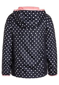 Giacca navy con pois bianchi, cappuccio, polsini elasticizzati e foderata di rosa. Il design presenta uno yoke sul retro e un orlo arricciato.
