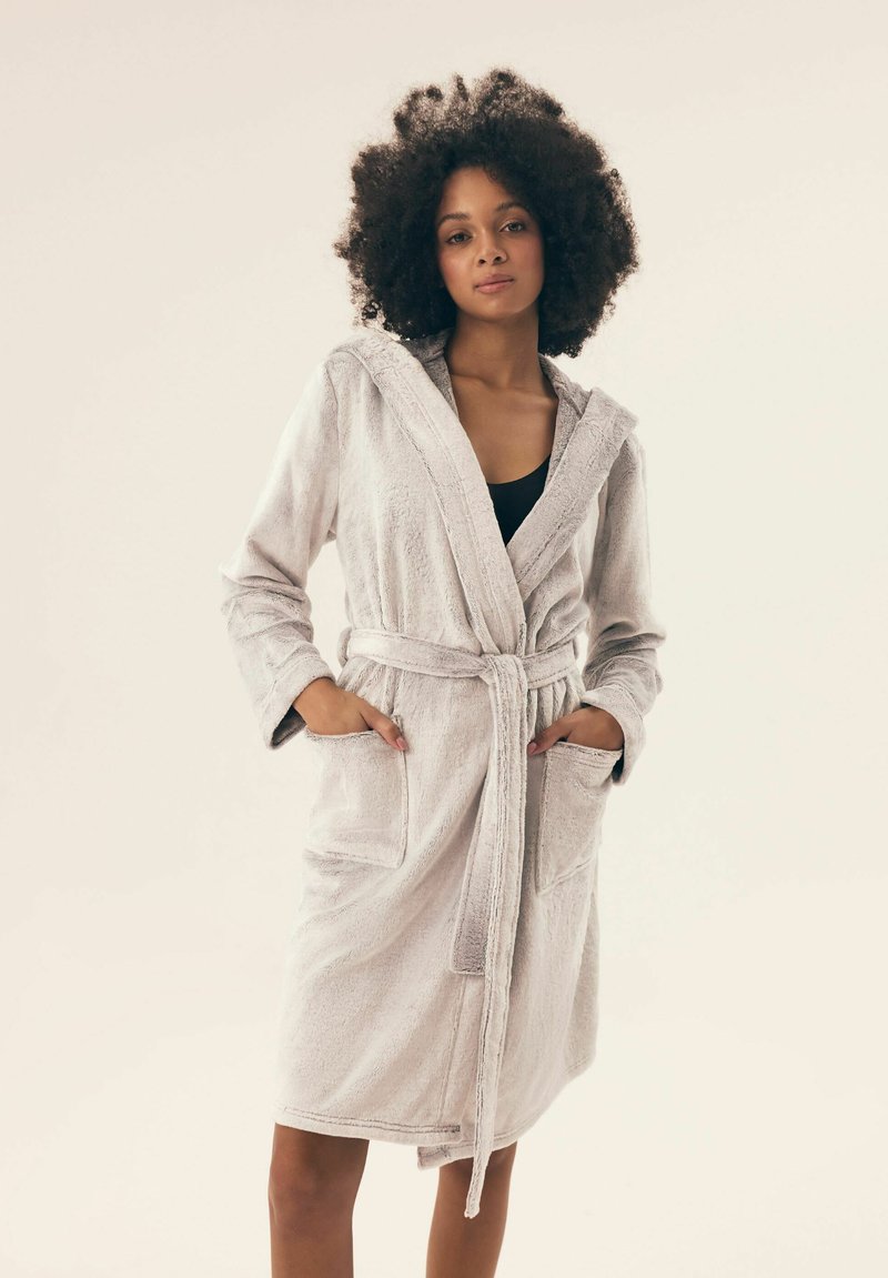 Jasnoszara pluszowa szlafrok z kapturem, wiązaniem w talii oraz przednimi kieszeniami. Miękka tekstura i długość do kolan zapewniają komfort i łatwość noszenia.