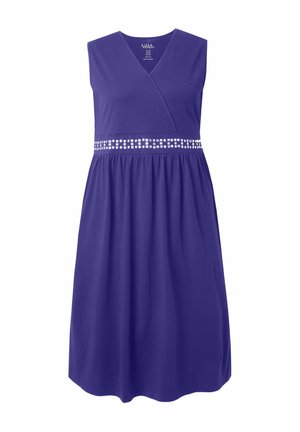 Fioletowa sukienka bez rękawów z kopertowym dekoltem w kształcie litery V i zdobionym paskiem w talii, z marszczonym dołem sięgającym poniżej kolan.