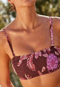 Bordový kvetinový bikiny top s smockovanou textúrou, tenkými nastaviteľnými ramienkami a dizajnom s veľkými ružovými a bielymi kvetmi.
