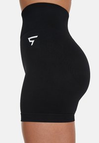 High-waisted black shorts made of smooth fabric with a snug fit. Features a white logo on the side and elastic waistband.