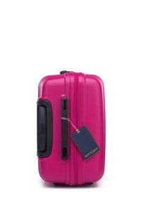 La maleta rígida rosa de Wittchen presenta una superficie texturizada, cremalleras dobles, un asa lateral y una etiqueta de equipaje adjunta.