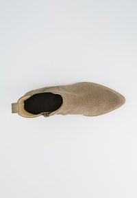 Beige sääristikud, millel on terav nina, sile tekstuur, külgtasku sulgemisega ja minimaalne disain. Lame talla ja kerge õmbluse detail.