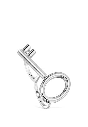 Srebrny pierścionek zaprojektowany jako vintage klucz z owalnym uchwytem i dwoma krótkimi zębami na jednolitym białym tle.