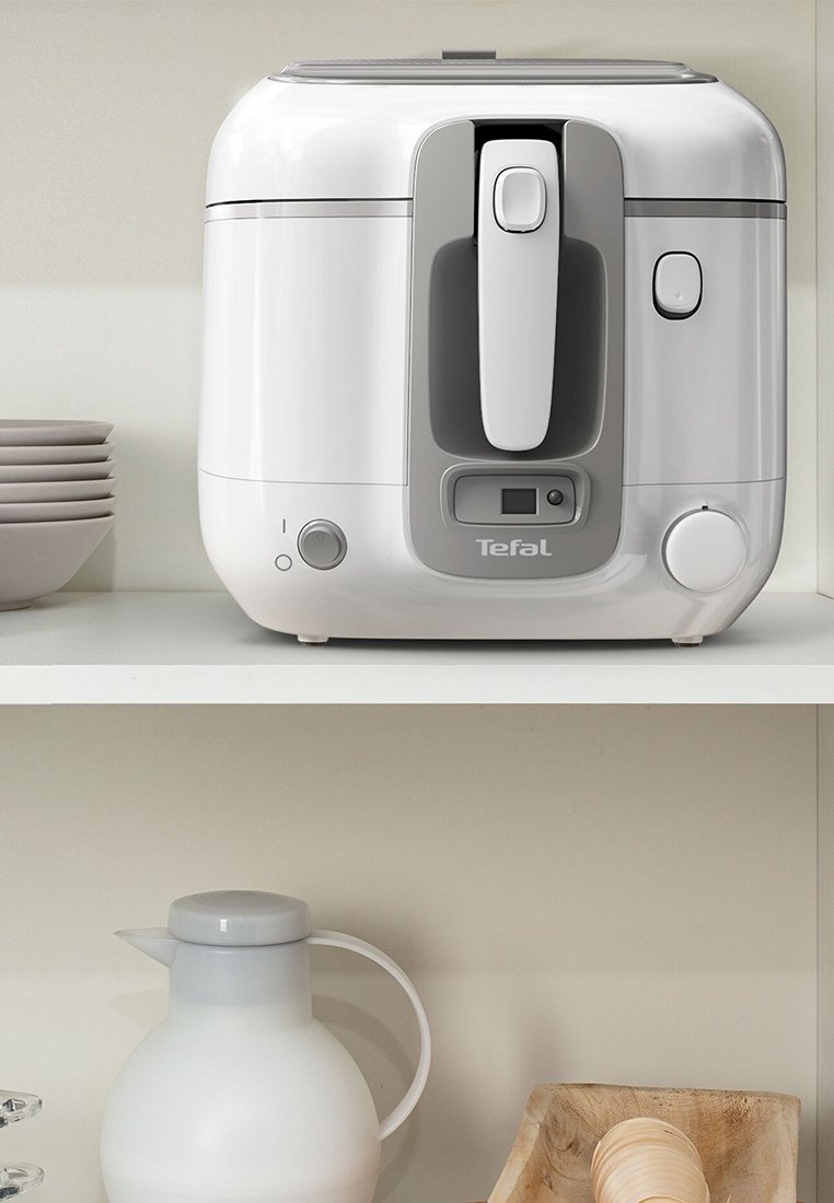 Frytkownica na powietrze Tefal, biała plastikowa obudowa z szarymi akcentami, z uchwytem, panelem sterującym i okrągłym pokrętłem z przodu.