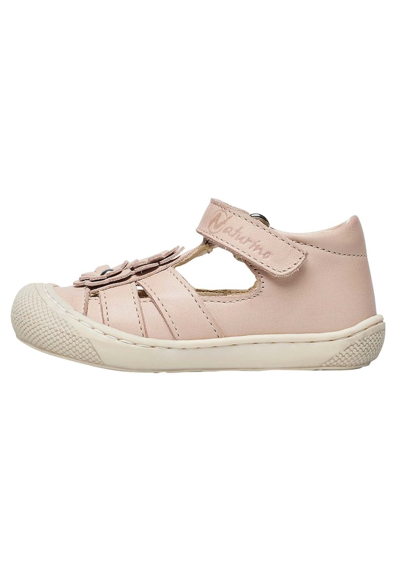Pink leather children's shoe, featuring a velcro strap, cut-out design, decorative flower accents, and a textured rubber sole.