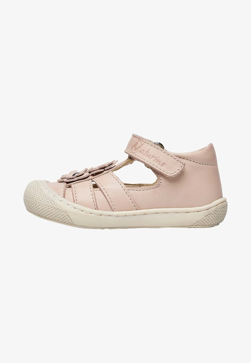 Pink leather children's shoe, featuring a velcro strap, cut-out design, decorative flower accents, and a textured rubber sole.