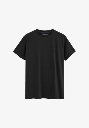 T-shirt nera a maniche corte con scollo rotondo e piccolo logo bianco di un giocatore di polo sul petto a sinistra.