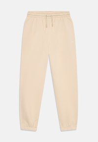 Pantaloni sportivi bej deschis, cu talie elastică și manșete, șnur de ajustare și un mic logo Jumpman alb pe partea superioară a coapsei stângi.