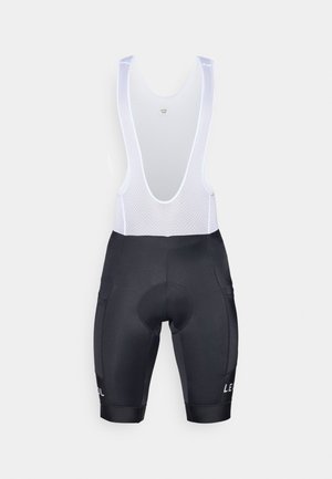 Pantaloni da ciclismo neri con bretelle in rete bianca e dettagli con logo. Texture liscia, forma aderente e due tasche laterali.