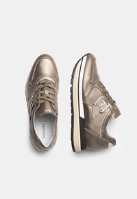 Sneakers in bronzo metallico con superfici strutturate, punta arrotondata e suola nera a contrasto. Caratterizzate da una chiusura con lacci e dettaglio del logo sul lato.