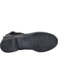 Chaussure en cuir noir avec une semelle en caoutchouc texturé. Présente un bout arrondi et un détail de boucle subtil sur le dessus. Durable et conçue pour une bonne adhérence.