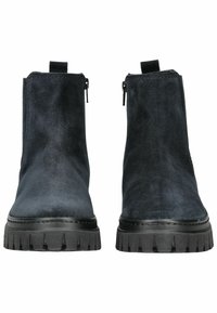 Bottines en daim bleu marine avec une finition lisse, semelle en caoutchouc noir, zips avant et languettes pour un enfilage facile.