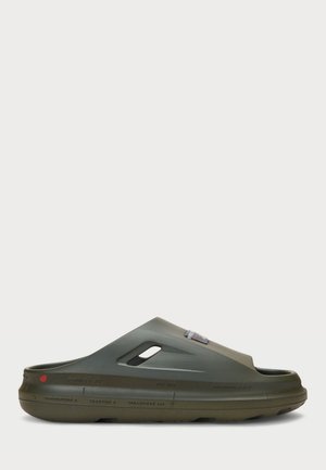 Chanclas de goma verdes con un diseño curvado, corte en la parte frontal, orificios de ventilación en los laterales y un acento de logo en la parte superior.