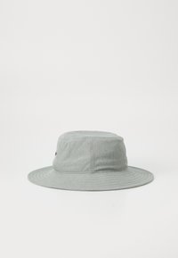 Grå bøttehatt laget av myk stoff med en bred, flat skjerm. Har en strukturert topp og minimal merkevarebygging på siden.