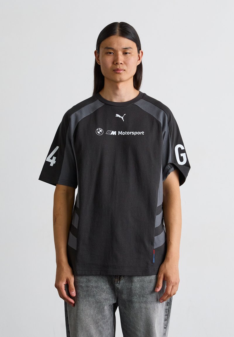 Sort bomuld t-shirt med grå detaljer, featuring rund hals, korte ærmer og hvide logoer. Bemærkelsesværdigt nummer "4" og bogstav "G" på ærmerne.