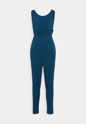 Sleeveless dark teal jumpsuit with a fitted waist, crisscross front detail, and tapered straight-leg pants.