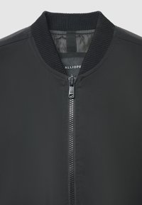 Schwarze Bomberjacke mit geripptem Kragen und Bündchen. Verfügt über einen Frontreißverschluss, eine glatte Stoffstruktur und ein innen aufgedrucktes Labeldetail.