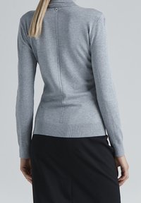 Szary dzianinowy sweter z długimi rękawami, stójką i przeszyciami z tyłu. Posiada ściągacze na mankietach i dole dla lepszego dopasowania.