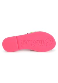 Vaaleanpunainen kumipohja kengästä, jossa on kaiverrettu teksti. Pinta on sileä, mutta siinä on hienoinen tekstuuri ja pyöristetty kantapää.