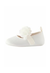 Weiße Ballettflats aus Stoff mit runder Zehenpartie und Blumenverzierung. Verfügt über einen pinken elastischen Riemen und ein weiches Innenfutter.