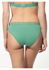 Grüne Baumwollunterhose mit Spitzenbesatz am Bund, klassischer Schnitt und glatter Textur. Die Rückansicht zeigt ein Design mit vollem Bedeckung.