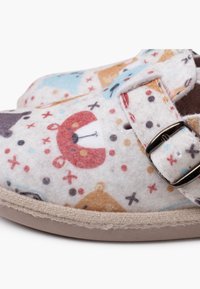Schlüpfschuhe aus weichem, gemustertem Filz mit bunten Tiermotiven. Enthält eine metallene Schnalle und eine beige Gummisohle.